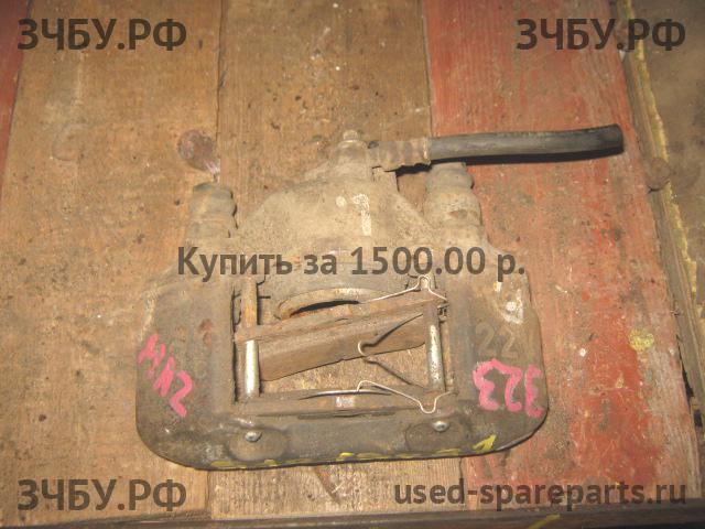 Mazda 323 [BA] Суппорт передний левый (в сборе со скобой)